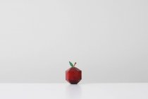 Manzana roja elaborada en forma geométrica imitando el origami de papel - foto de stock