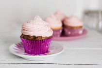 Quatro cupcakes em uma mesa, fundo borrado — Fotografia de Stock
