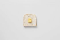 Konzeptioneller Buttergeist auf Brot vor weißem Hintergrund — Stockfoto