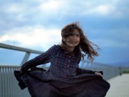 Дівчина в картатій сукні танцює у вітрі — стокове фото
