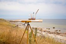 Cavalete de arte em pé na grama na praia — Fotografia de Stock