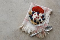 Blick über den Kopf auf Joghurt-Parfait mit Müsli und frischen Beeren — Stockfoto