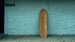 Wooden leaning against wall by women restroom — Stock Photo