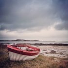 Red and white boat on grass, Jura, Inner Hebrides, Scotland, UK — Stock Photo