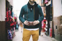 Крупным планом молодого человека с винтажной ретро-камерой на рынке — стоковое фото