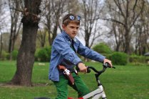 Хлопчик прикидається поліцейським на велосипеді в парку — стокове фото
