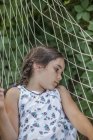 Pensativo chica acostado en hamaca al aire libre - foto de stock