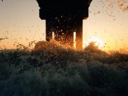 Sonnenaufgang unter der Seebrücke mit Splash und Sonnenfacare, USA, Florida, St. Augustine Beach — Stockfoto