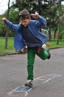 Хлопчик грає хмарочос на одній нозі на вулиці — стокове фото