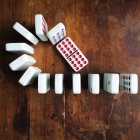 Fila de dominós em uma mesa de madeira, vista superior — Fotografia de Stock