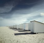 Fila de cabañas de playa blanca en la playa de arena, s-Gravenzande, Holanda - foto de stock