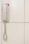 Vista de primer plano del teléfono blanco colgado en la pared - foto de stock