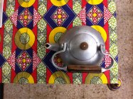Top view of teapot on colorful printed tablecloth — Stock Photo