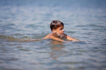 Petit garçon nageant en mer en été — Photo de stock