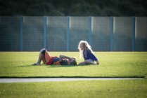 Menino e menina falando em um campo de futebol — Fotografia de Stock