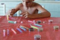 Boy making bead necklaces, focus on colorful beads — Stock Photo