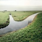 Живописный вид на пейзаж с рекой и полем — стоковое фото