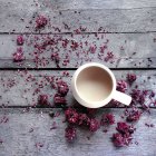 Mug of tea surrounded by dried flower blossoms — Stock Photo