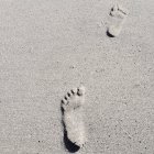 Human barefoot footprints on grey background — Stock Photo