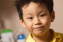Портрет усміхненого азіатського хлопчика, який дивиться на камеру — стокове фото
