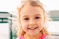 Portrait of smiling blond girl looking at camera — Stock Photo