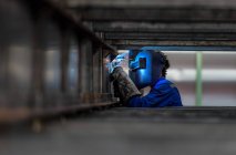 Nahaufnahme des Arbeiters mit Schutzmaske beim Schweißen von Metall — Stockfoto