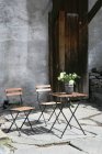 Table basse avec des fleurs et des chaises à l'extérieur — Photo de stock