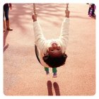 Retrato de uma menina sorridente sentada em um balanço no parque infantil — Fotografia de Stock