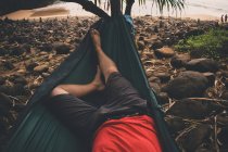 Visão de seção baixa do homem relaxante na rede, EUA, Ilhas Havaí, Kauai — Fotografia de Stock