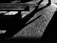 Обрезанный образ человека, идущего по улице и бросающего тень — стоковое фото