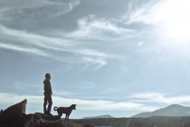 Mann steht auf Felsen mit Hund und Blick auf die Aussicht, USA, colorado, el paso county, pikes peak — Stockfoto
