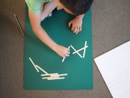 Мальчик учится математике в начальной школе с палками — стоковое фото