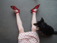 Preto cão sentado ao lado de menina deitado no chão — Fotografia de Stock