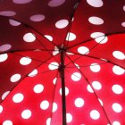 Vista sob aberto vermelho guarda-chuva sagacidade pontos brancos — Fotografia de Stock