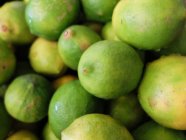 Close-up of fresh green limes in heap — Stock Photo