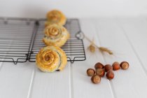 Chocolate hazelnut swirl pastries on rack on white wood — Stock Photo