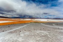 Bolívia, Altiplano, Paisagem com céu nublado acima da lagoa vermelha — Fotografia de Stock
