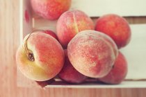 Верхний вид ящика из свежих вкусных персиков — стоковое фото