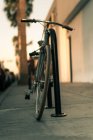 Vista de perto da bicicleta estacionada na rua ao pôr-do-sol — Fotografia de Stock