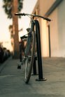 Vista de cerca de la bicicleta Estacionado en la calle al atardecer - foto de stock