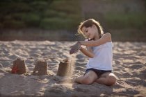 Sorridente ragazza che gioca sulla spiaggia di sabbia — Foto stock