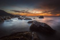 Vista panorámica de la puesta de sol sobre la costa rocosa - foto de stock