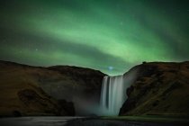 Aurores boréales sur la cascade de Skogafoss, Islande — Photo de stock