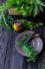 Свіжі трави, тарілки та ножиці над дерев'яним столом у фіолетових тонах — стокове фото