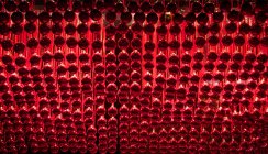 Vista de ángulo bajo de filas de adornos rojos colgantes - foto de stock