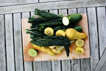 Повышенный вид на фрукты и овощи на доске — стоковое фото
