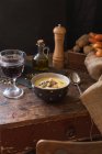 Чаша картофельного супа с бокалом красного вина — стоковое фото