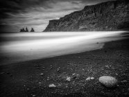 Monochrome image of sea stacks seen from the beach in Vik, Iceland — Stock Photo