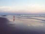 Ragazzo che cammina lungo la spiaggia al crepuscolo, Florida, America, Stati Uniti — Foto stock