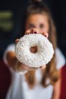 Beautiful young woman holding a sweet tasty doughnut — Stock Photo